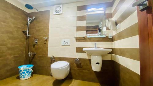 a bathroom with a sink and a toilet at Willo stays The Metro Landsend Beach Resorts in Kannur