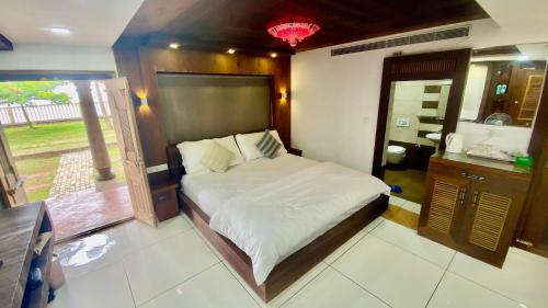 a bedroom with a large bed in a room at Willo stays The Metro Landsend Beach Resorts in Kannur