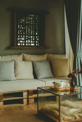 a living room with a couch and a glass table at Hide and see in Sha-p'ing-pa