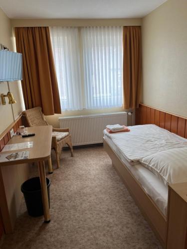 a hotel room with a bed and a desk at Hotel Herzog in Hamm