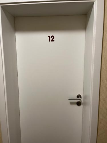 a white door with the number twelve on it at Hotel Herzog in Hamm