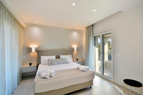 a bedroom with a large bed with towels on it at Villa Verde, Kobitsi Corfu in Corfu