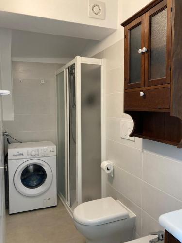 a bathroom with a toilet and a washing machine at Casa Gaia, La Casa Sui Tetti in Isolabona