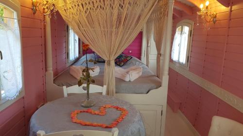 Cette chambre dispose d'une table avec un cœur. dans l'établissement Roulottes O Bois D'mon Coeur, à Bussac-Forêt