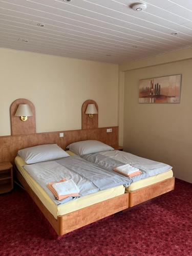 a bedroom with a large bed with two towels on it at Hotel Herzog in Hamm