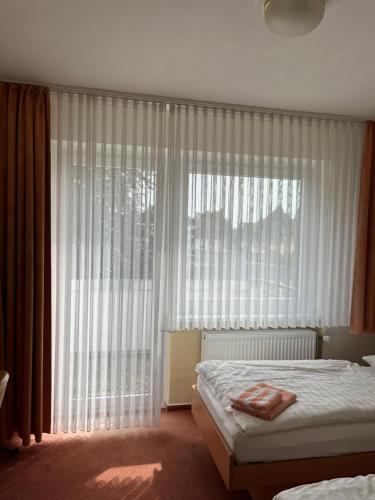 a bedroom with a bed and a large window at Hotel Herzog in Hamm