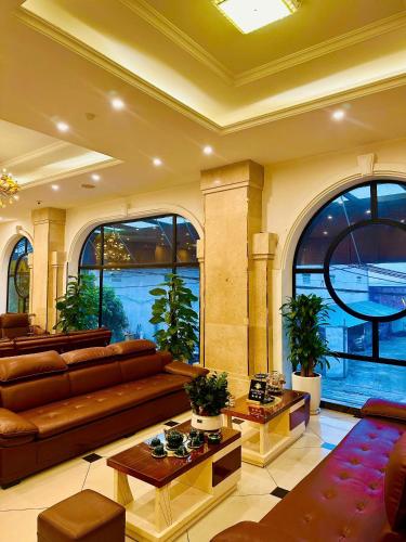a large living room with a couch and tables at Sunrise Hanoi Hotel in Hanoi