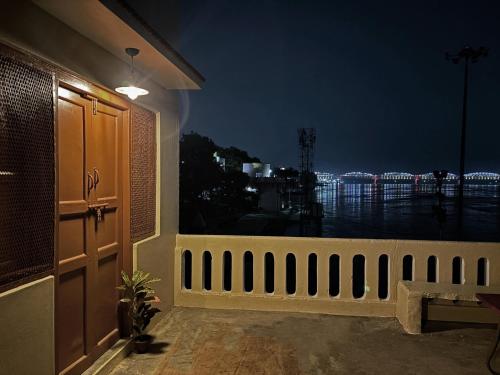 a balcony with a view of the ocean at night at Vintage River Homestay in Varanasi