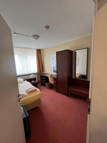a hotel room with a bed and a desk at Hotel Herzog in Hamm