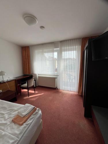 a hotel room with a bed and a desk at Hotel Herzog in Hamm