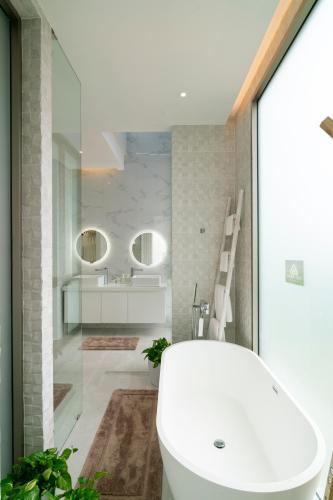 a bathroom with a white tub and a sink at Andaman Villa 15 minutes from Bangtao Beach in Phuket Town