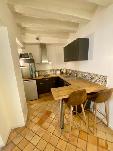 une cuisine avec une table en bois et deux chaises dans l'établissement Logement entier - Vieux Tours - Centre, à Tours