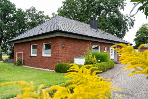 a red brick house with a black roof at Vechteblick in Schüttorf