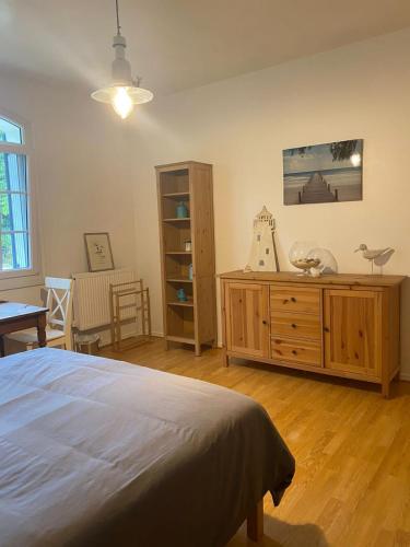 une chambre avec un lit et une commode en bois dans l'établissement Au Cœur des Acacias, à Lauzun