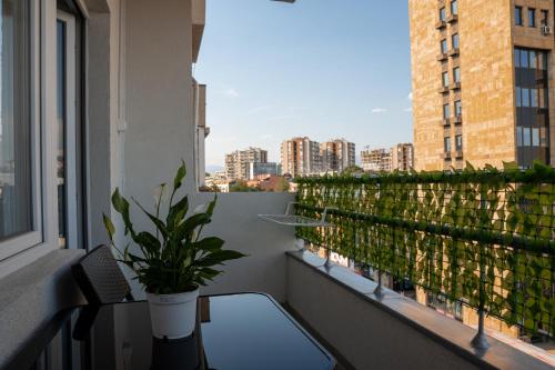 a balcony with a table and a potted plant at Fantasy apartment in Skopje