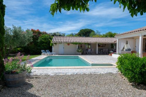 a house with a swimming pool in a yard at Le Bariole, luxury villa with heated pool in Cesseras