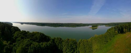 an aerial view of a lake surrounded by trees at Mazurskie Wzgórze Nad Jeziorem Isąg in Pelnik