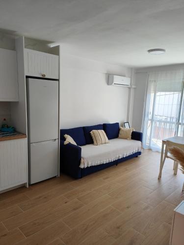 a living room with a blue couch in a kitchen at Apartamento Ferrandis Benicasim in Benicàssim