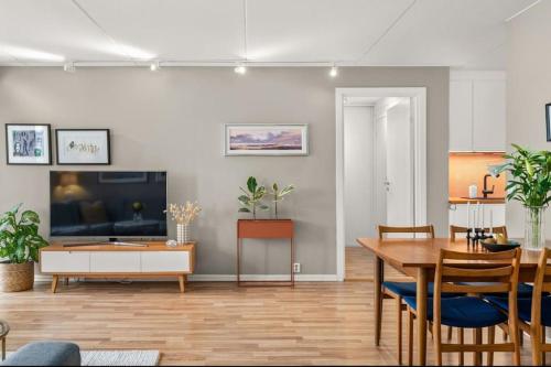a living room with a dining table and a television at Sentral & Cozy apartment in Oslo