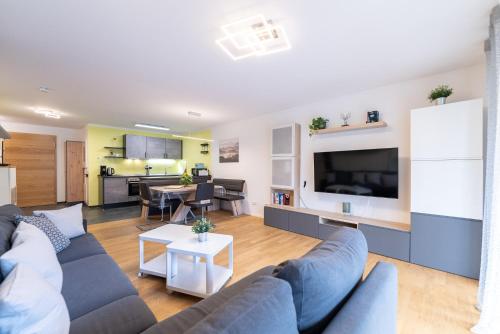 a living room with a couch and a tv at Ferienwohnung BUTTERBLUME, Feldberg - Haus Wiesenquelle in Feldberg