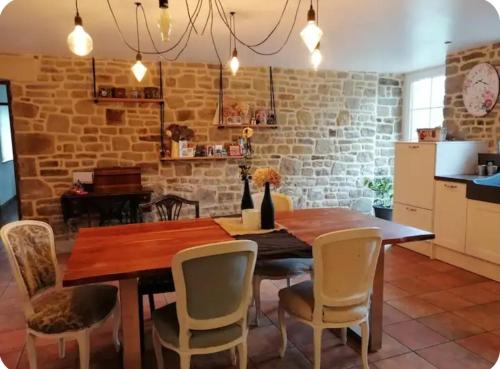 une salle à manger avec une table et des chaises en bois dans l'établissement Havre de paix, à La Bloutière