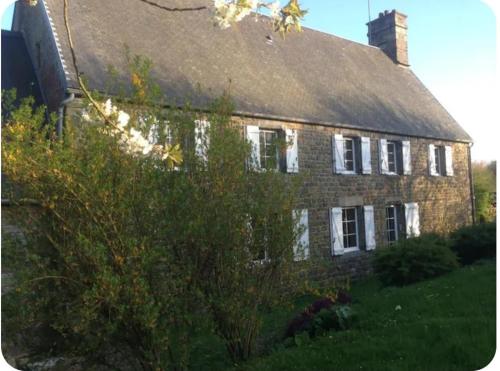 une ancienne maison en briques avec un toit dans l'établissement Havre de paix, à La Bloutière