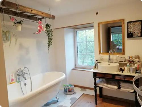 une salle de bain avec une baignoire et un lavabo dans l'établissement Havre de paix, à La Bloutière