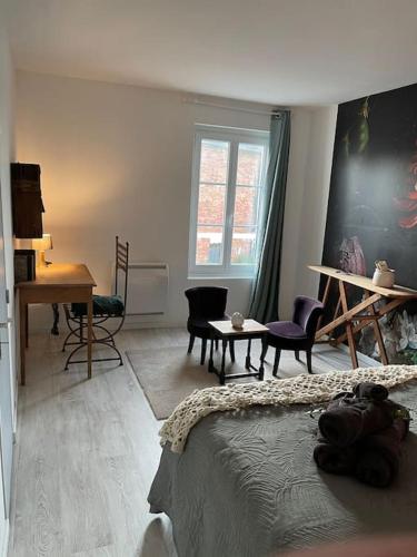 une chambre avec un lit, une table et des chaises dans l'établissement Maison Etadame, à Aizier