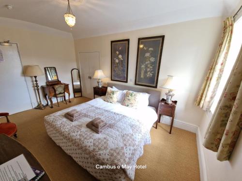 a bedroom with a bed with two towels on it at Cambus O' May Traditional Highland Hotel in Ballater