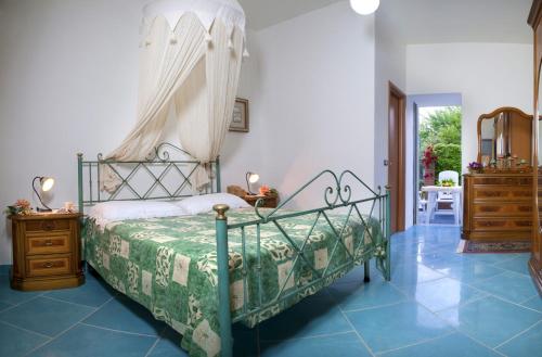 a bedroom with a bed with a canopy and blue tile floors at Casa Vacanza Alice & Mari in Ascea