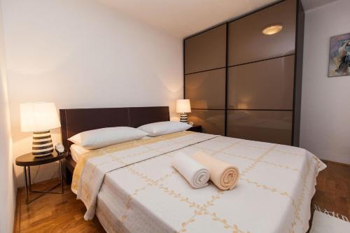 a bedroom with a large bed with two towels on it at Apartments Casa Mia in Dramalj