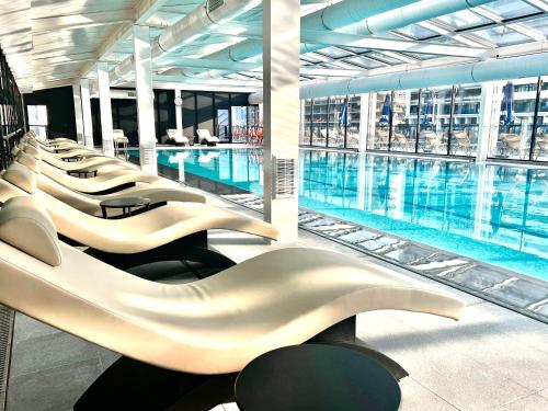 a large pool with rows of chairs next to a building at 33 Luxury in Batumi