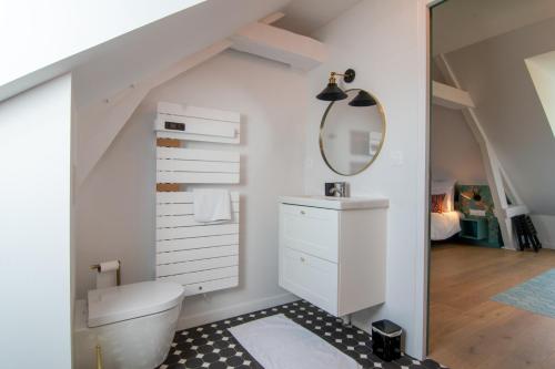La salle de bains mansardée est pourvue d'un lavabo et de toilettes. dans l'établissement Domaine des Horizons, à La Poterie-Cap-dʼAntifer