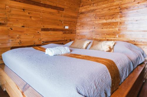 a bedroom with a bed in a wooden cabin at Phumork Camp Phu Chi Fa in Ban Huai Han