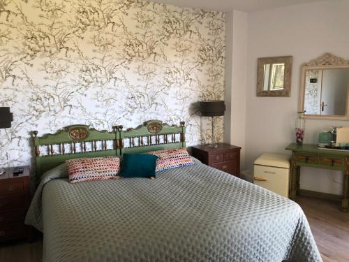 ein Schlafzimmer mit einem Bett und einer Tapetenwand in der Unterkunft Habitación deluxe con baño privado en Atalaya Apartagolf, Estepona in Estepona