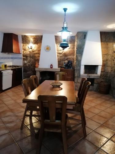 a kitchen and dining room with a wooden table and chairs at Villa Cantinho dos Avós in Baião