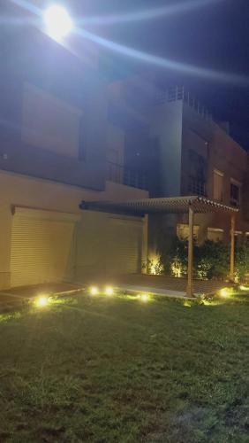 a building with lights in a yard at night at Townhousr at Etapa Zayed in Sheikh Zayed