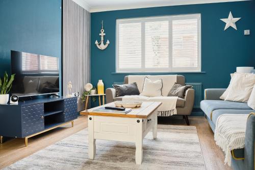 a living room with a couch and a tv at Beautiful Aldeburgh Coastal Getaway in Aldeburgh