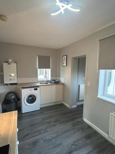 a kitchen with a stove and a washer and dryer at South Hetton Residence in South Hetton