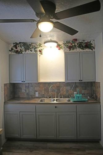 a kitchen with white cabinets and a ceiling fan at 1 bedroom with a fireplace close to base in Lawton