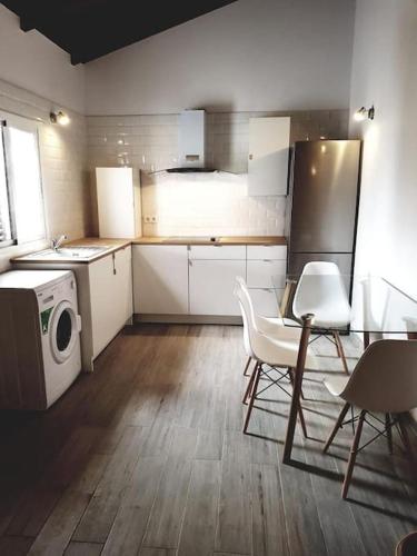 a kitchen with white cabinets and a table and chairs at Casa Alejandra en el palmar in Cádiz