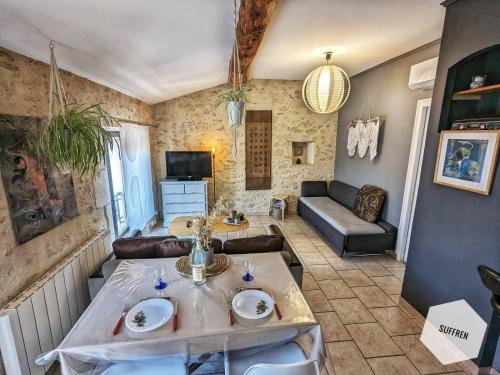 un salon avec une table et un canapé dans l'établissement Pause Nîmoise en centre ville - Toit terrasse & Clim, à Nîmes