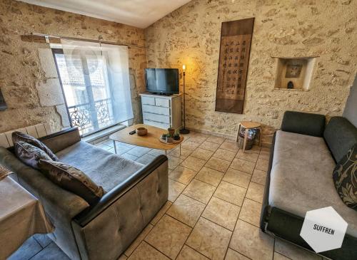 un salon avec un canapé et une télévision dans l'établissement Pause Nîmoise en centre ville - Toit terrasse & Clim, à Nîmes