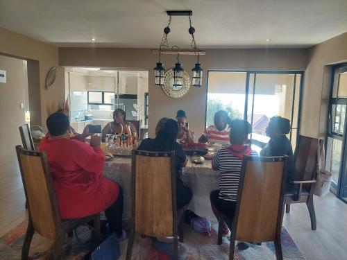 a group of people sitting around a table at Mohau Accommodation and Events GRACE in Elandsfontein