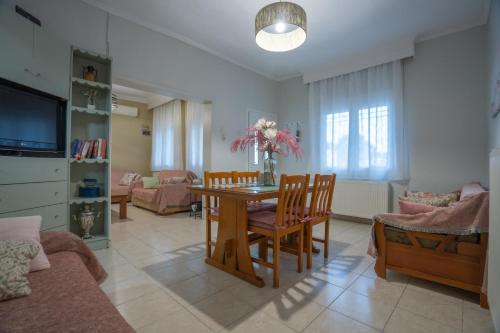a living room with a dining room table and chairs at Roots House Pozar in Piperiaí