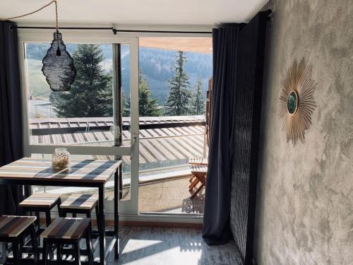 une salle à manger avec une table et une grande fenêtre dans l'établissement Studio cosy au pied des pistes, à Villard-de-Lans