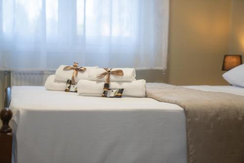 a pile of towels sitting on top of a bed at Roots House Pozar in Piperiaí
