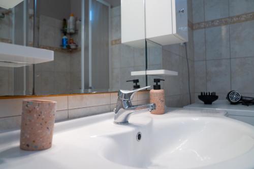 a bathroom sink with a faucet and a mirror at Roots House Pozar in Piperiaí