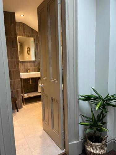 an open door to a bathroom with a sink at Lewis Lodge - Stunning & Exclusive Luxury Home in the Heart of Ballater, Royal Deeside in Ballater