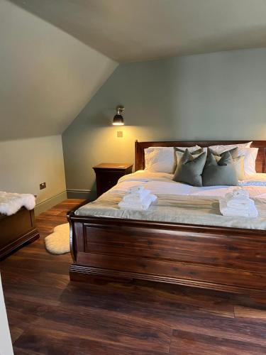 a bedroom with a large wooden bed with pillows at Lewis Lodge - Stunning & Exclusive Luxury Home in the Heart of Ballater, Royal Deeside in Ballater